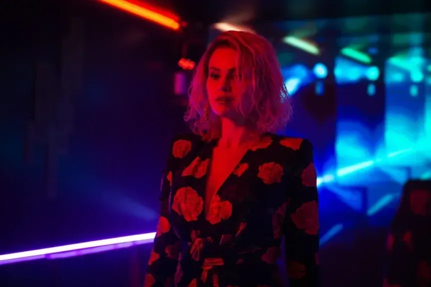 Selena Gomez standing in a dark room in the film Emilia Perez